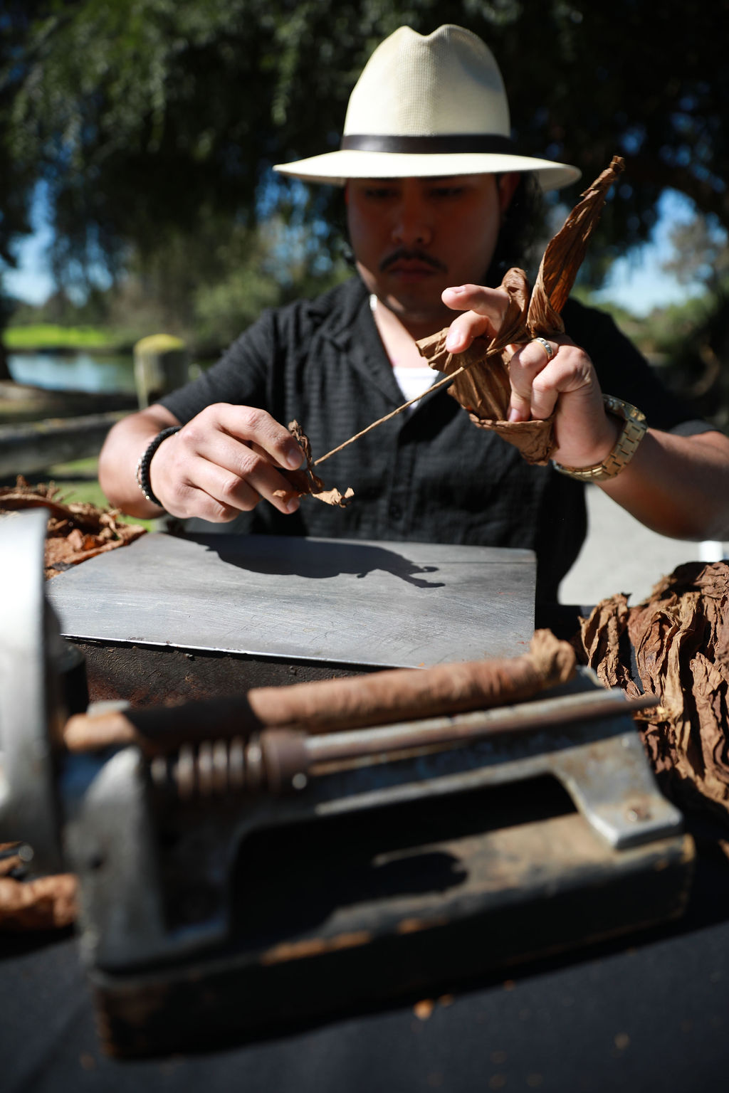 Master roller hand-finishing cigars at the cigar station