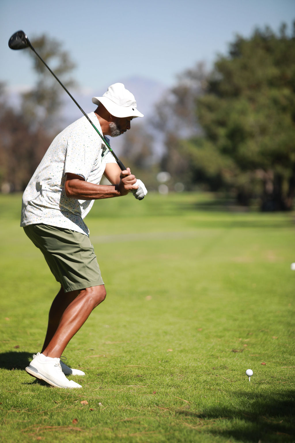 Player mid-backswing with a driver on the fairway