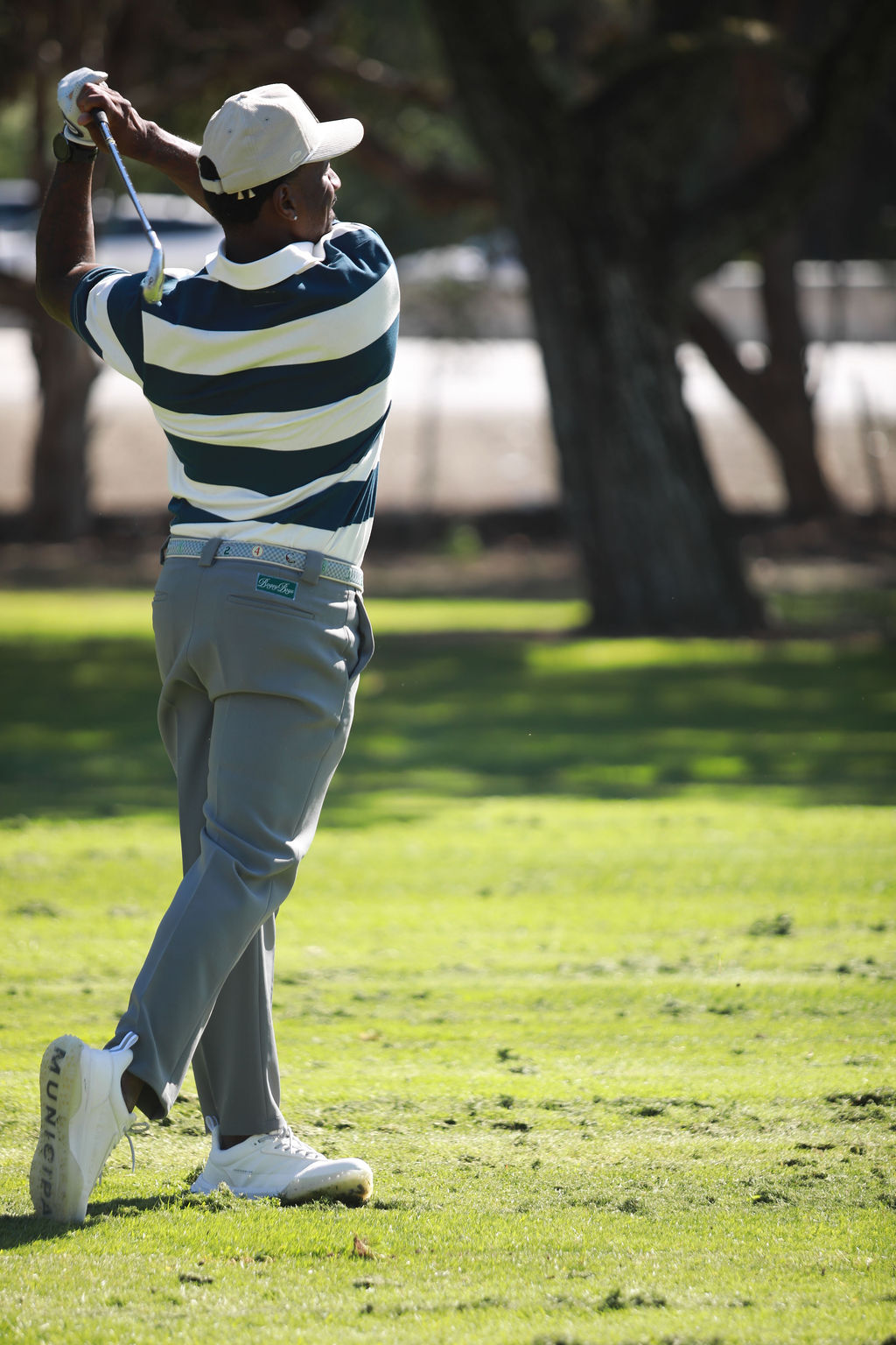 Player finishing a full swing on the fairway