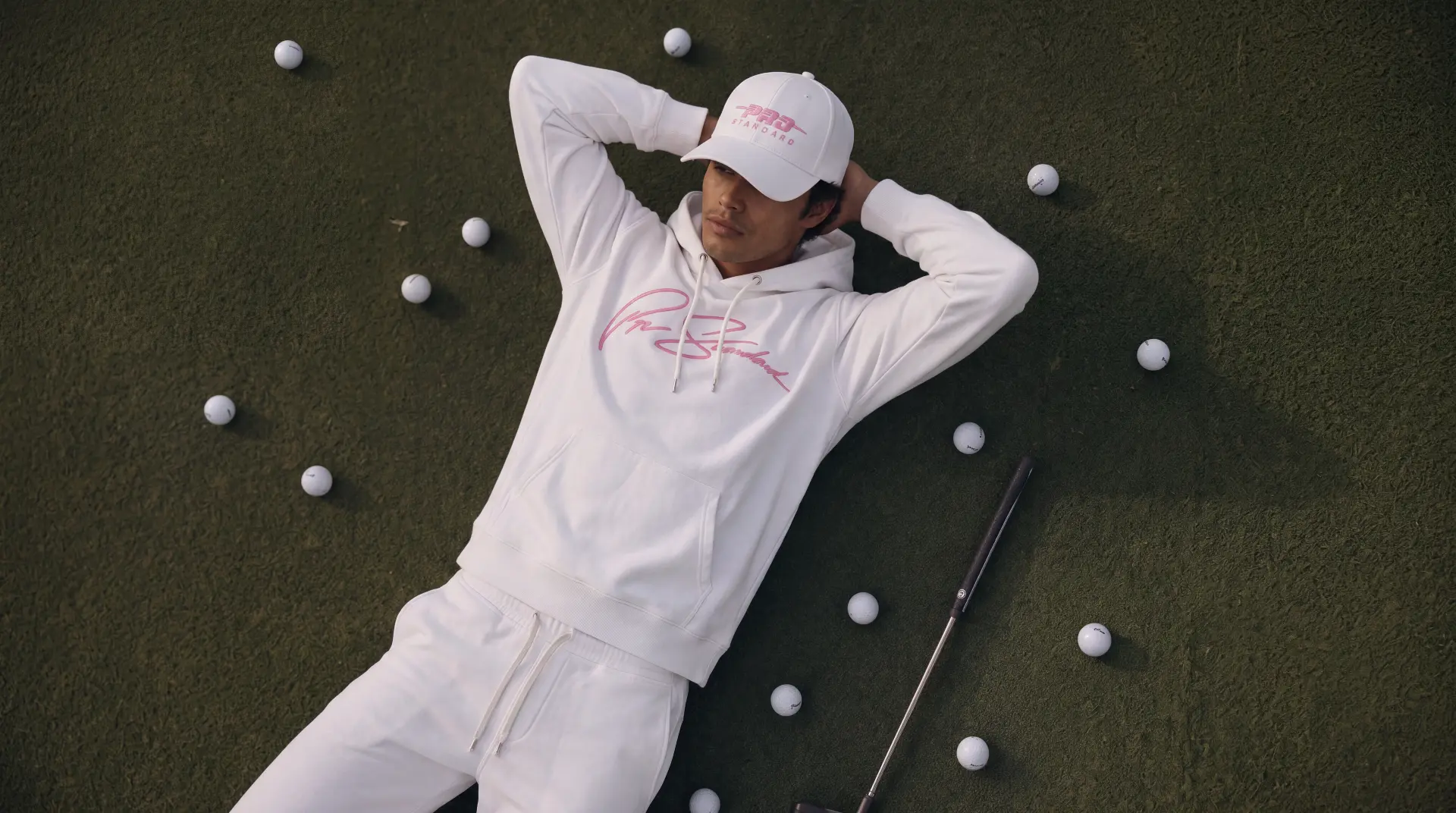 Pro Standard World of Golf hoodie, polo, cap and glove laid out on the green